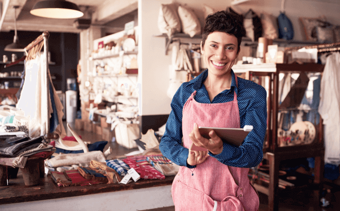 Foto de una mujer emprendedora, sonriendo en su repostería porque ha encontrado la fuente de financiamiento de pymes en Colombia para atender sus obligaciones financieras adquiridas.