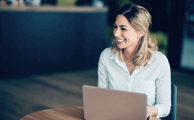Imagen de una mujer empresaria con cabello recogido ingresando desde su computador a la sucursal virtual empresas fiduciaria Bancolombia.